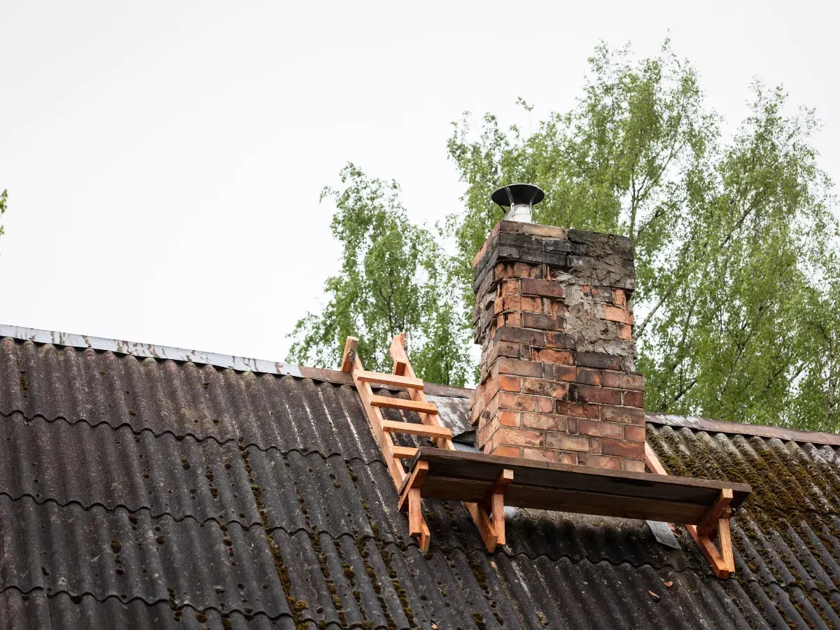Weathered brick chimney above a tiled roof