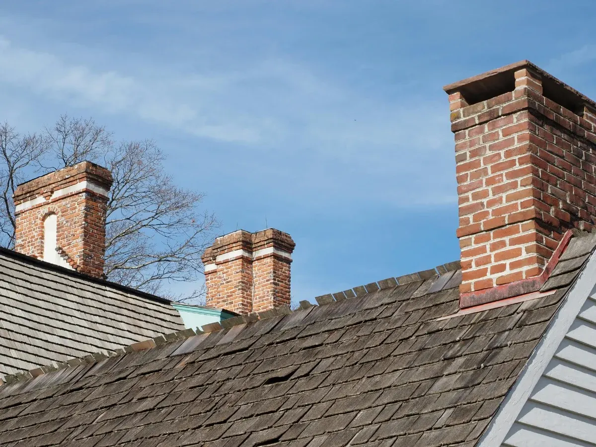 Brick chimneys above a shingle roof